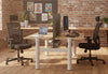 Fokus Ergonomic High-Back Chairs in black shown in a modern office interior, featuring two chairs positioned at work desks within a space with exposed brick walls, wooden flooring, natural light and greenery, highlighting contemporary ergonomic office seating and profesional workplace design.