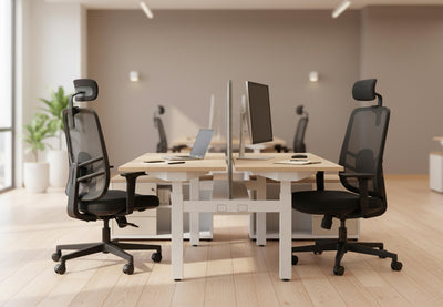 Two Fokus Comfort Chairs are prominently featured in a modern and bright office environment. These black ergonomic mesh office chairs offer excellent support for long hours of work, making them ideal for any productive workspace. The chairs are positioned at light wood desks with white legs, showcasing a comfortable and functional office setup. This image highlights the sleek design and practical features of the chair, perfect for businesses seeking high-quality office seating solutions.